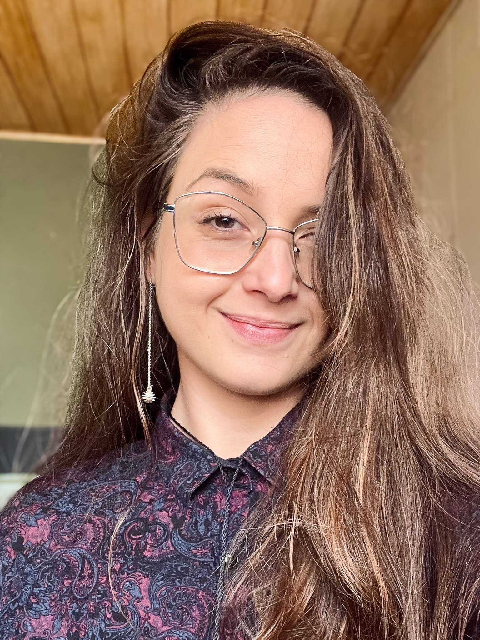 Bruna Silva, fundadora do Estúdio Bhuta, sorrindo, de óculos e camisa estampada